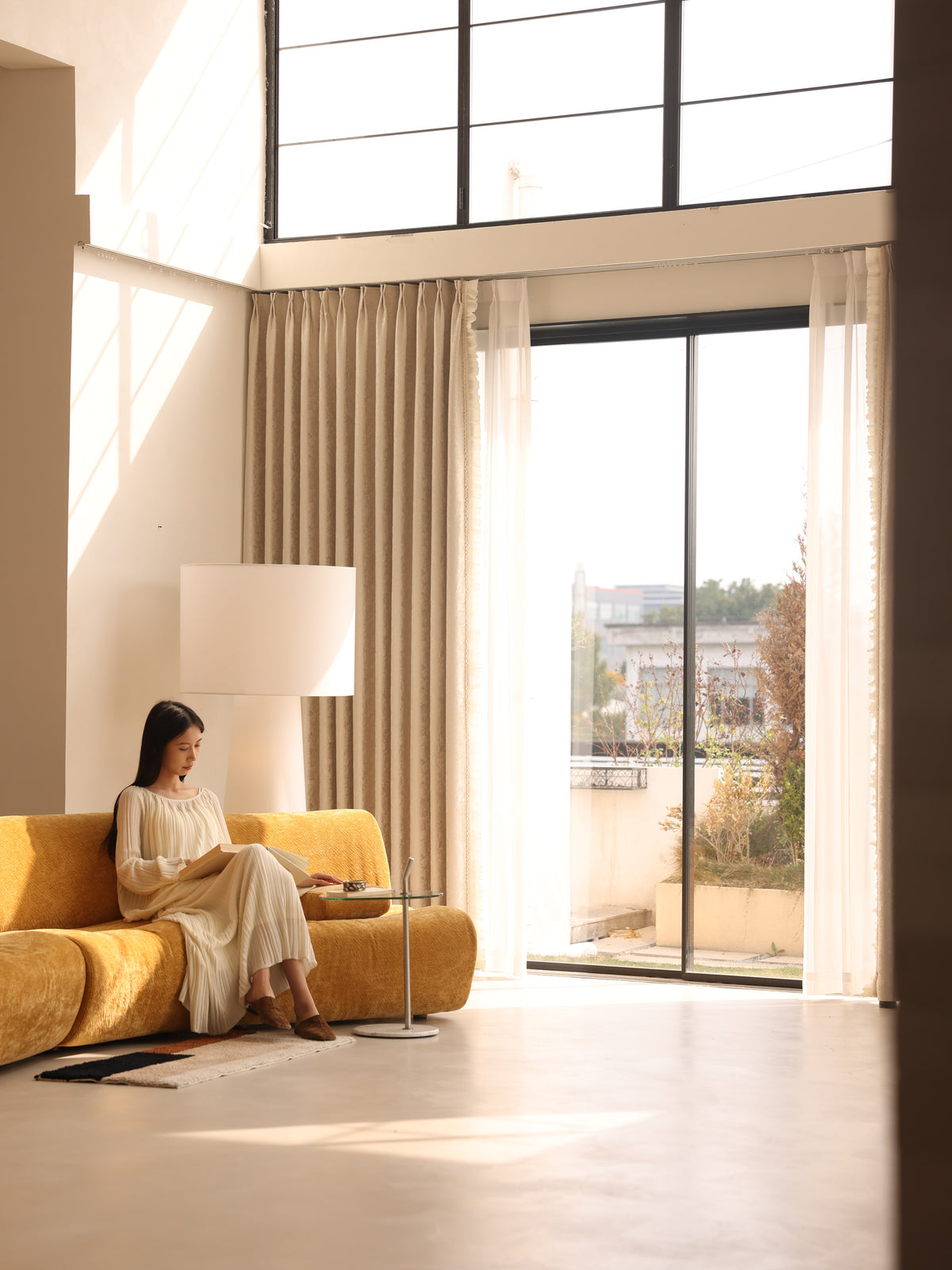 Floor-to-ceiling ivory blackout curtains in a sunlit modern living room