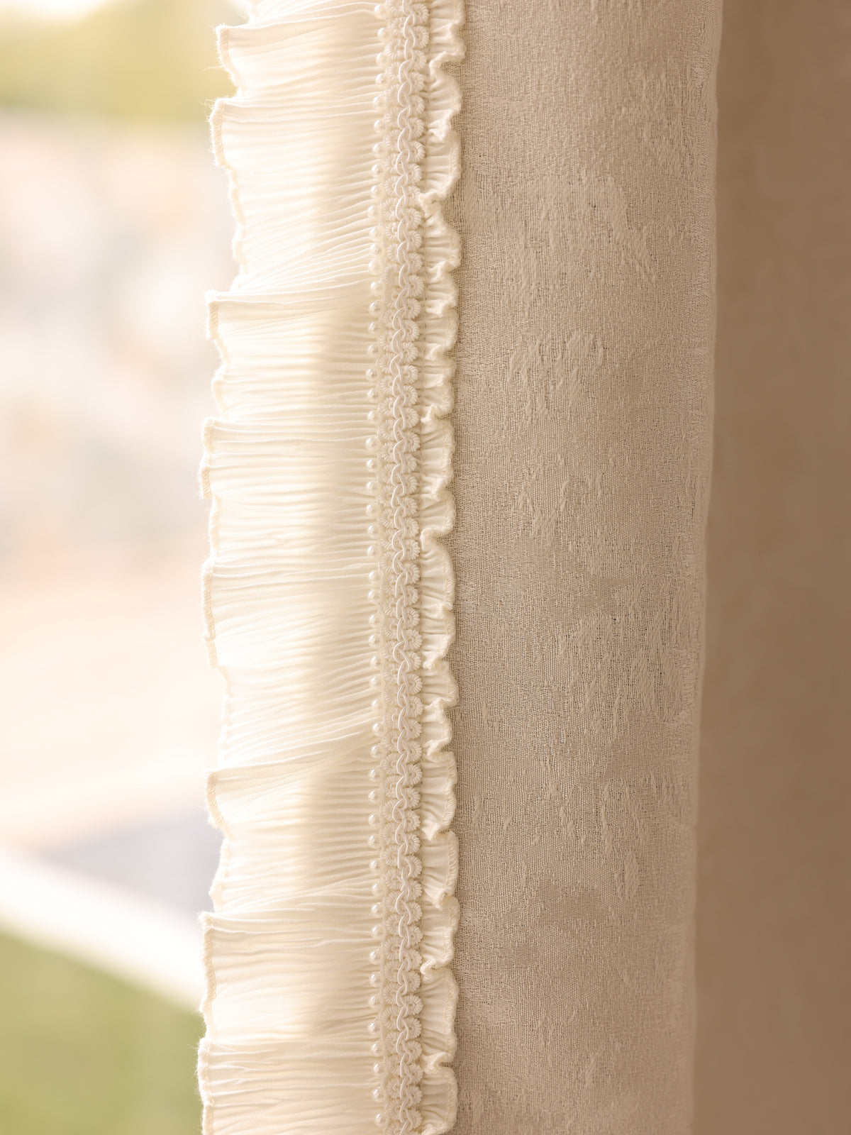 Detailed view of decorative pleated ruffle trim on chenille blackout fabric