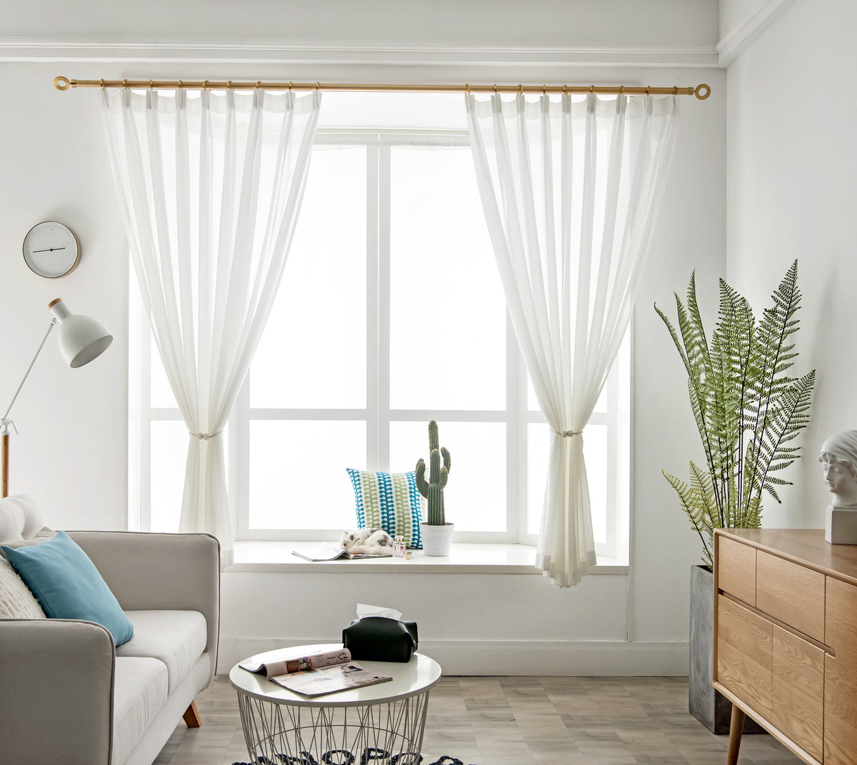 Pair of custom white diamond mesh sheer curtains tied back at a living room window